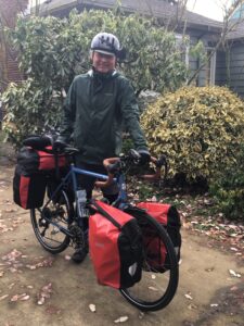 Wes Kempfer standing in drive way with bike loaded up with panniers full of gear.