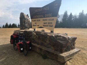 A loaded tour bike at the sign marking the Continental Divide at Hoosier Pass, elevation 11,529 ft
