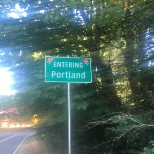 A green road sign saying "Entering Portland"